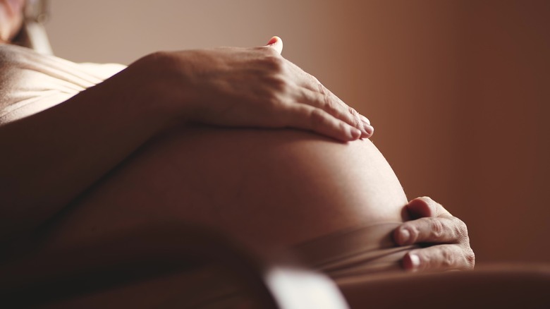 A woman touching her pregnant belly