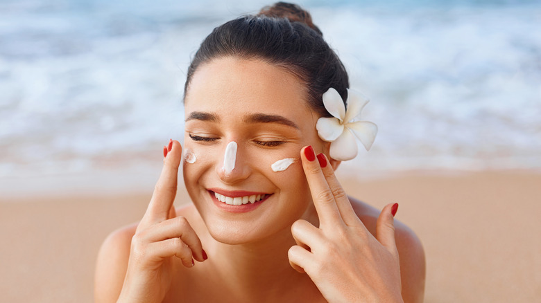 Woman applying sunscreen to her face 