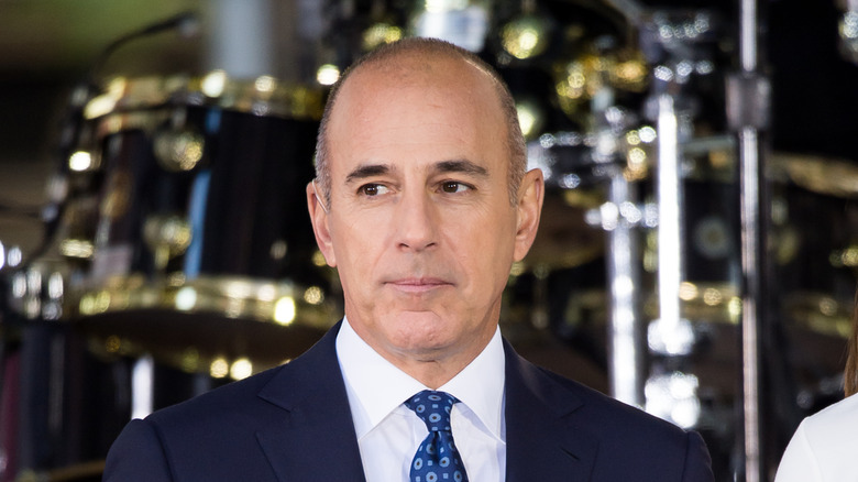 Matt Lauer posing in front of a drum kit