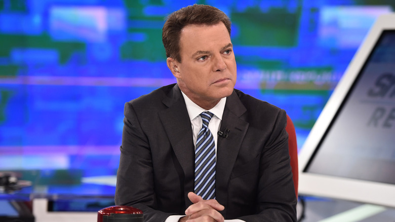 Shepard Smith sitting behind a desk in a TV stufio