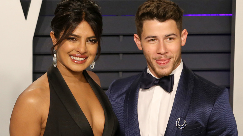 Nick Jonas has his arm around Priyanka Chopra
