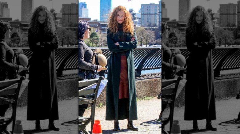 Nicole Kidman pictured in NYC in 2019, wearing a dark orange skirt, striped turtleneck, long blue-green coat, and black boots
