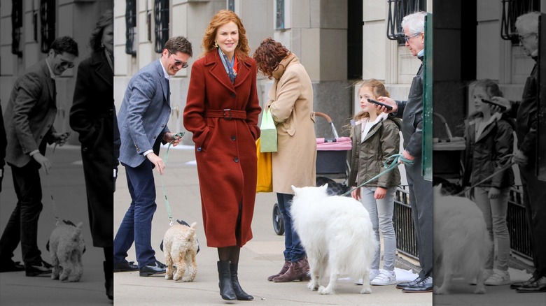 Nicole Kidman pictured wearing a dark orange belted trenchcoat and boots in New York City, with her daughter Faith Margaret