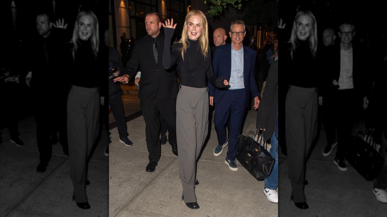 Nicole Kidman pictured in New York City wearing a black mock turtleneck top and gray-ish suit trousers