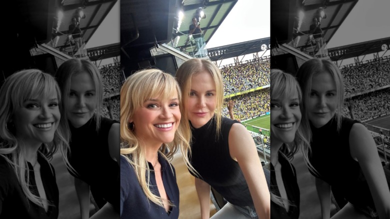 Reese Witherspoon and Nicole Kidman take a selfie together at a football game, both smiling at the camera with their faces close together