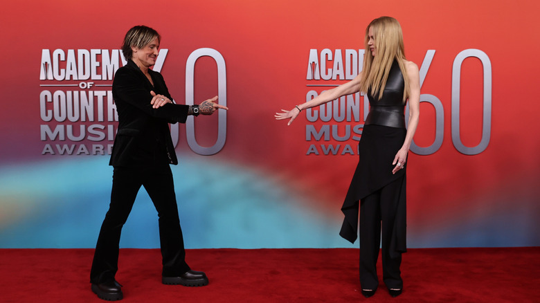 Nicole Kidman reaching out for Keith Urban's hand