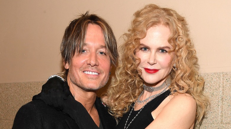 Nicole Kidman with warm blond ringlet curls posing with Keith Urban