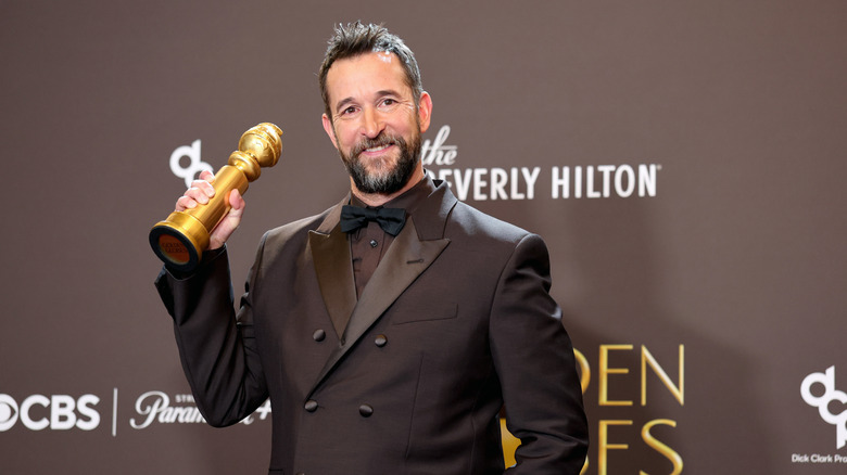 Noah Wyle holding his Golden Globe.