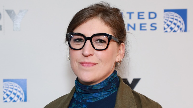 Mayim Bialik smiling in black glasses