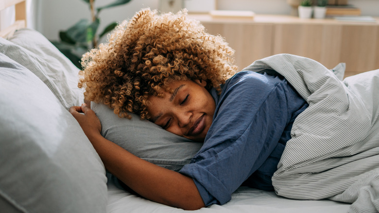 smiling woman laying in bed