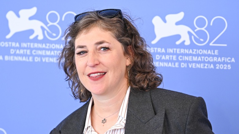 Mayim Bialik wearing a suit and sunglasses on her head at the Venice Film Festival.