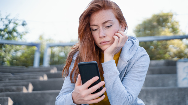 bored woman looking at phone