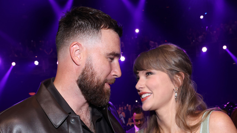 Taylor Swift and Travis Kelce smiling at each other