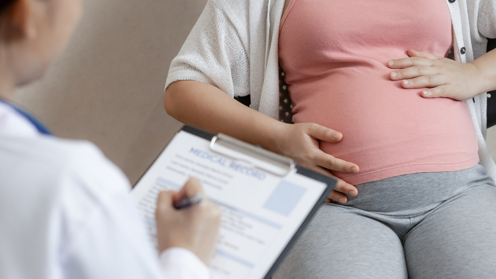 A pregnant person and their doctor 