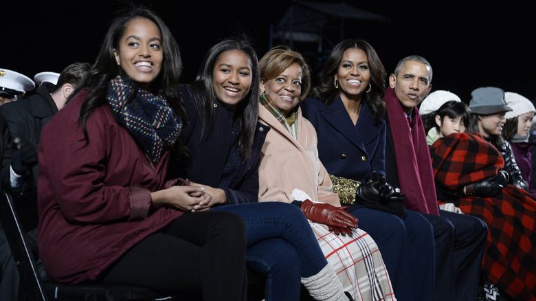 Barack Obama and his family smiling while sitting at an event