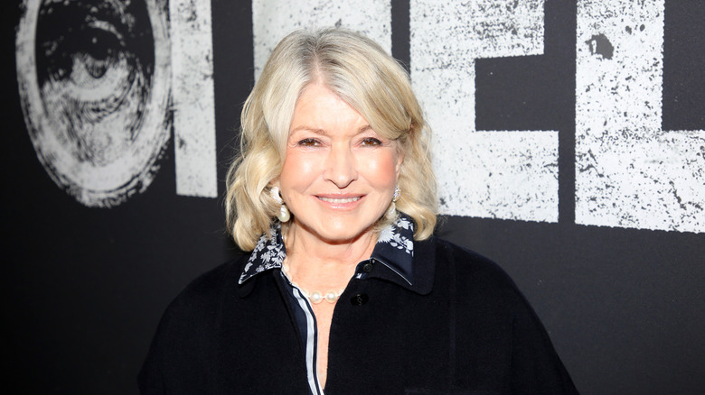 Martha Stewart smiling while posing at an event in a black top