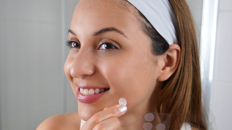 Woman applying pimple patch