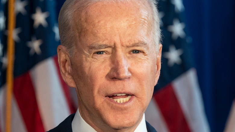 President Joe Biden in front of flags 