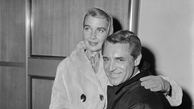 Cary Grant and Betsy Drake sitting close to each other.