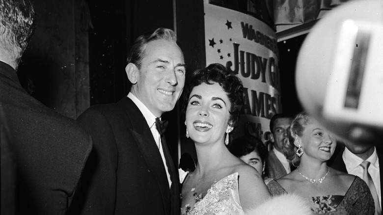 Elizabeth Taylor and Michael Wilding smiling for cameras.