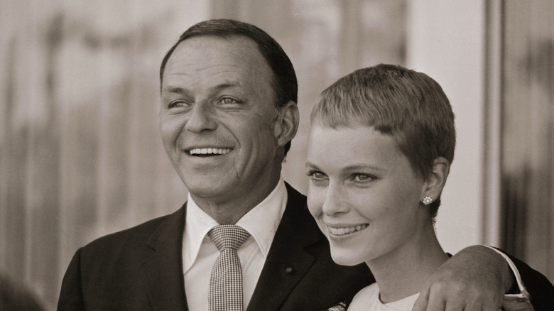 Frank Sinatra smiling with his arm around Mia Farrow.