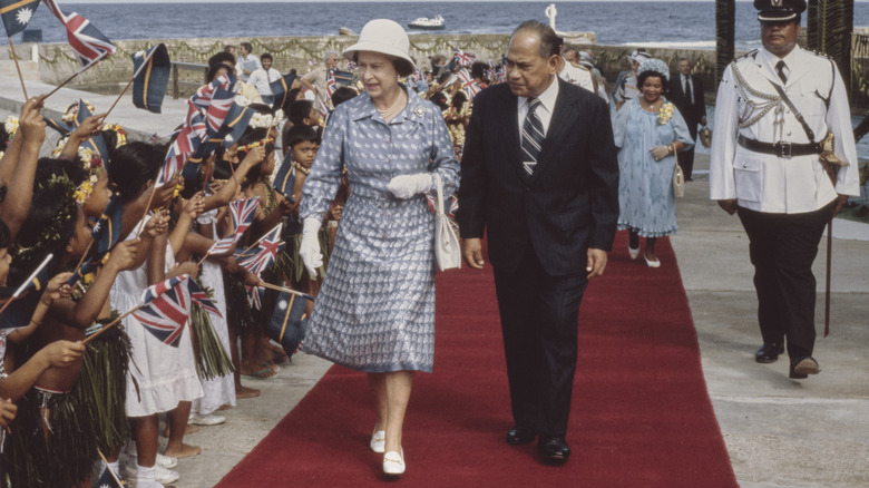 Queen Elizabeth wears a helmet hat in the Soloman Islands