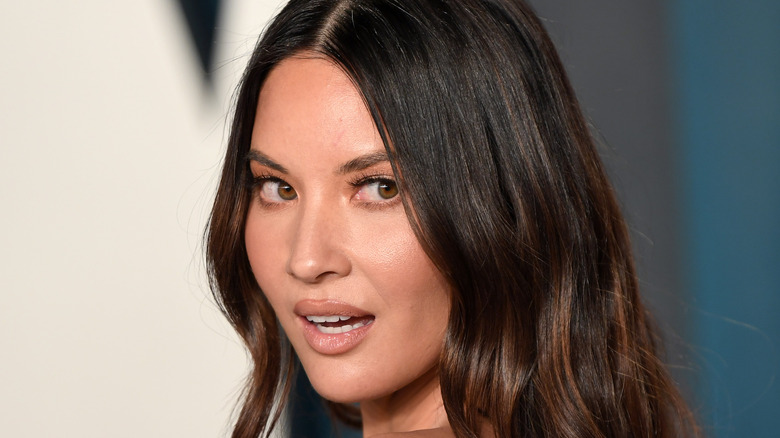 Olivia Munn looking over her shoulder on the red carpet