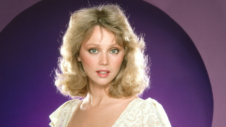 Shelley Long posing for a portrait in front of a purple backdrop