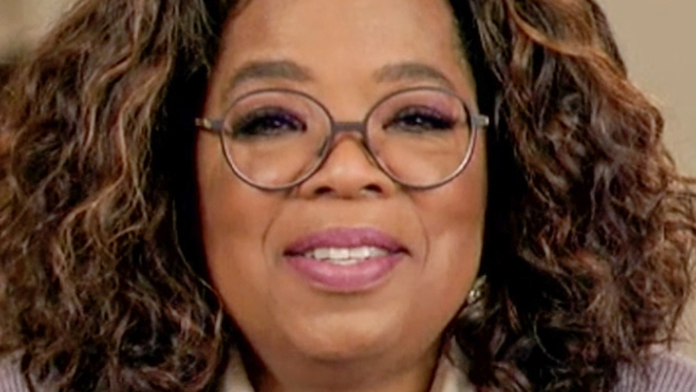 Oprah smiling, wearing glasses