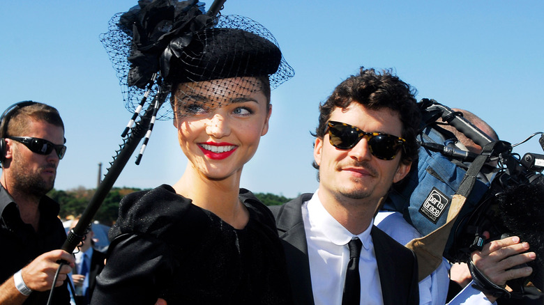 Miranda Kerr and Orlando Bloom pose next to a camera man and sound operator in 2009.