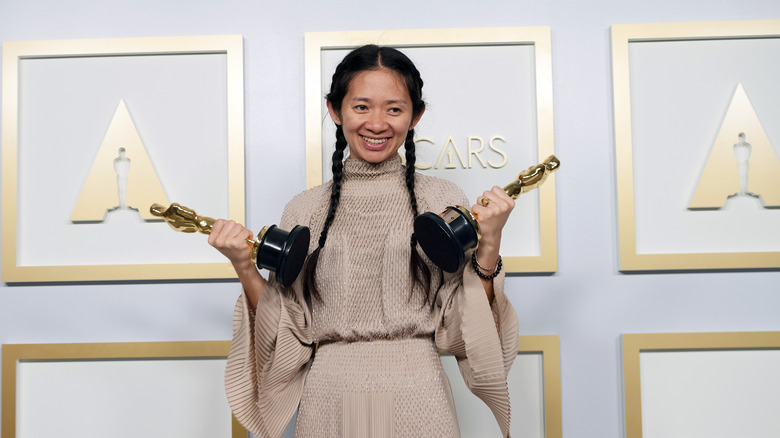 Chloe Zhao posing with awards