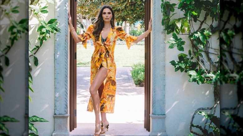 Bettina Anderson poses in an orange dress for her Instagram (2021)