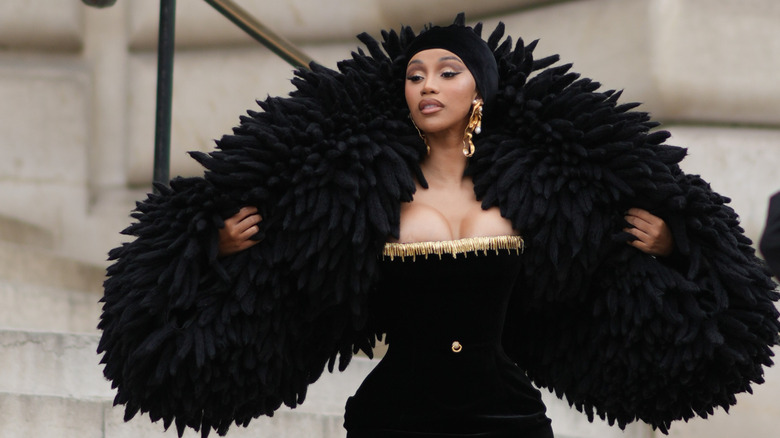 Cardi B posing in elaborate black scarf