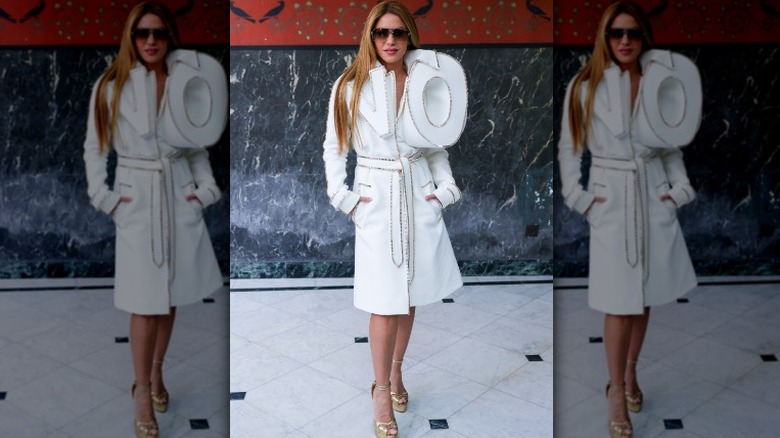 Shakira posing in white ensemble