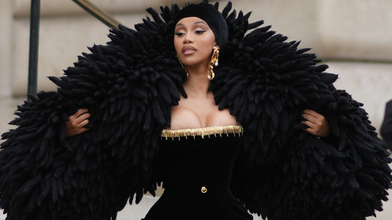 Cardi B posing in elaborate black scarf