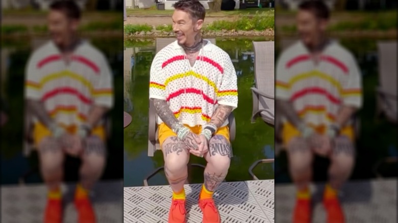 David Bromstad wearing orange sneakers, yellow shorts, and a white shirt with yellow and red stripes