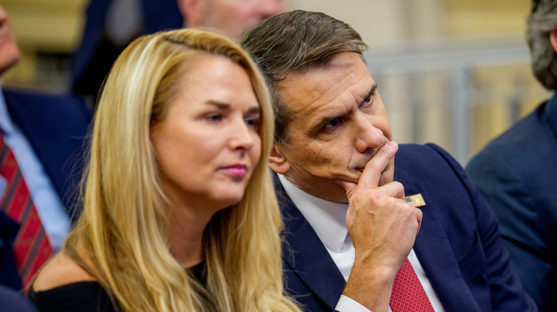 Kristine and Todd Blanche attentively listening as Todd puts his hand over his mouth