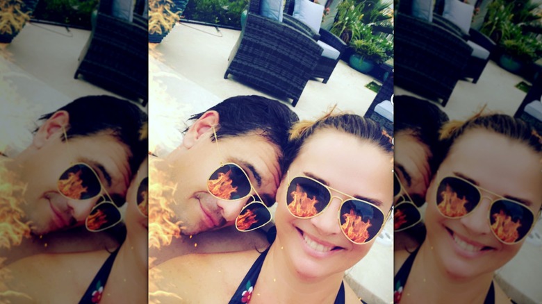Todd and Kristine Blanche pose for a beach day selfie with a flaming sunglasses filter