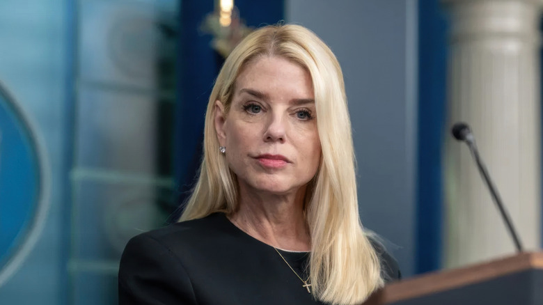 Pam Bondi listening intently to an audience member while standing at the podium