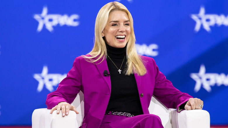 Pam Bondi in a pink suit speaking at the 2025 CPAC