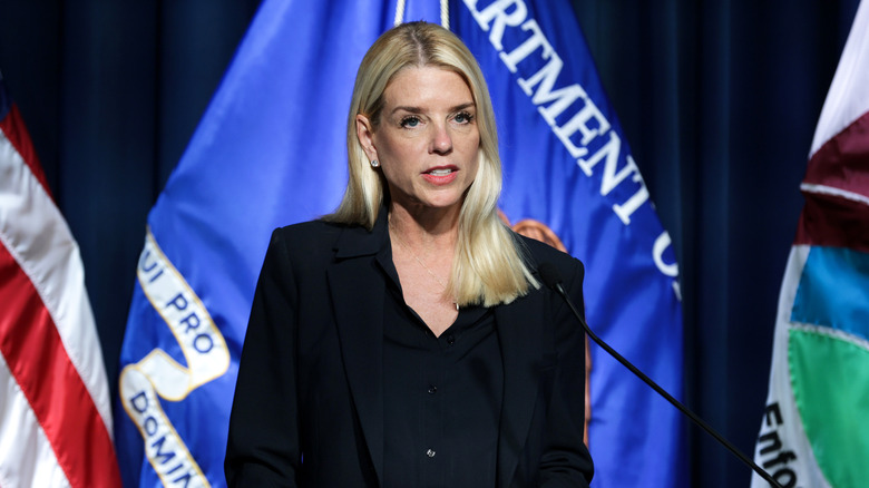 Pam Bondi stands behind a podium