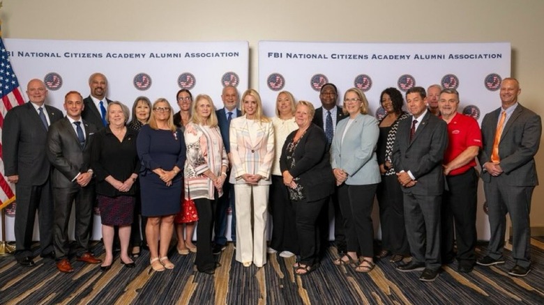 Pam Bondi smiling in the middle of a group of people