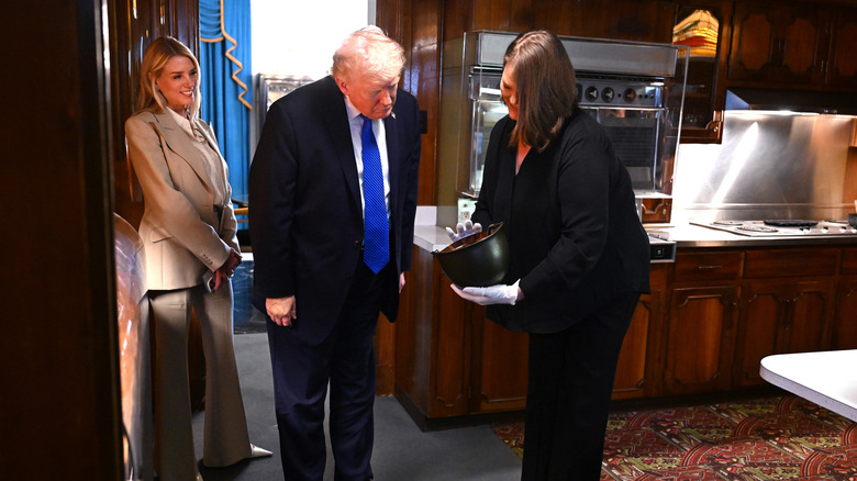 Pam Bondi watching Donald Trump talk to a tour guide