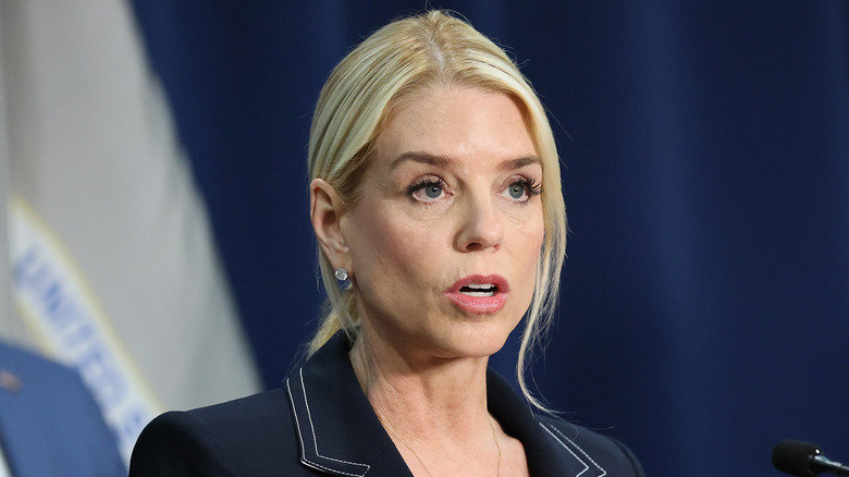 Pam Bondi stands at a microphone