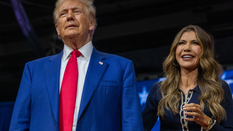 Donald Trump and Kristi Noem standing together on stage