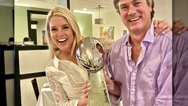 Pam Bondi and John Wakefield hold the Lombardi Trophy together (2021)