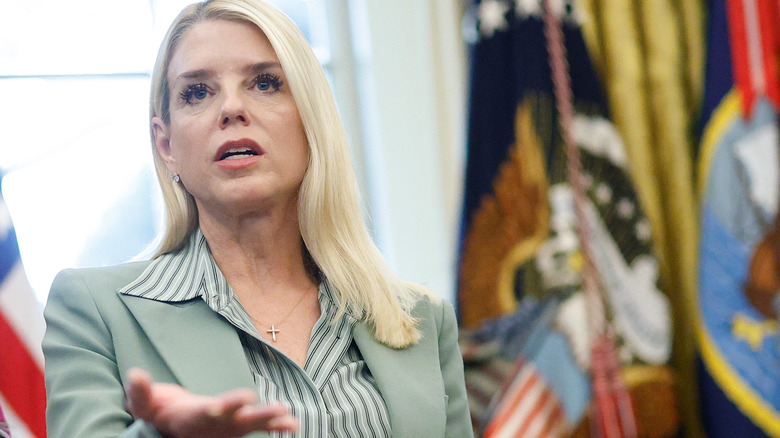 Pam Bondi looking up green blazer striped shirt
