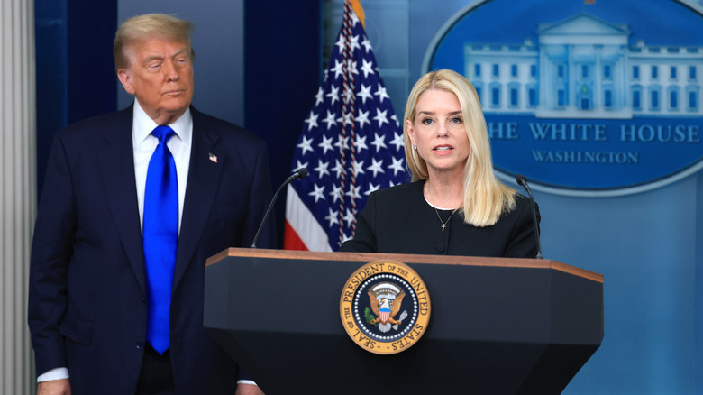 Donald Trump watching as Pam Bondi speaks at podium