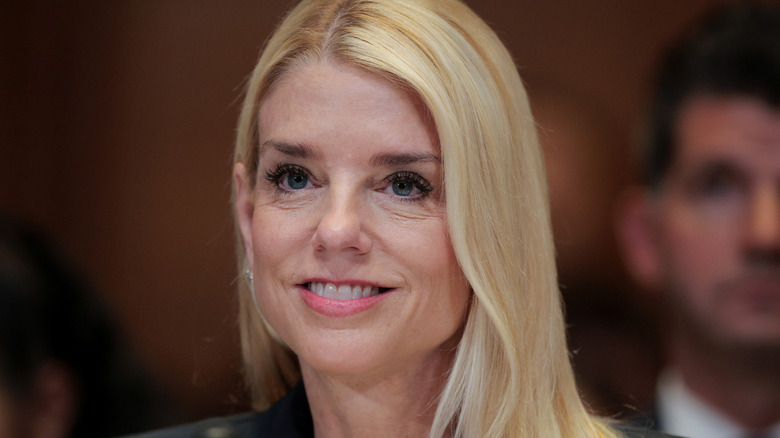 Pam Bondi wearing a black suit and smiling at the Dirksen Senate Office Building in Washington D.C.