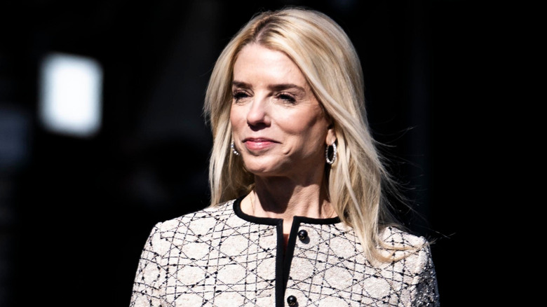 Pam Bondi walks while smiling